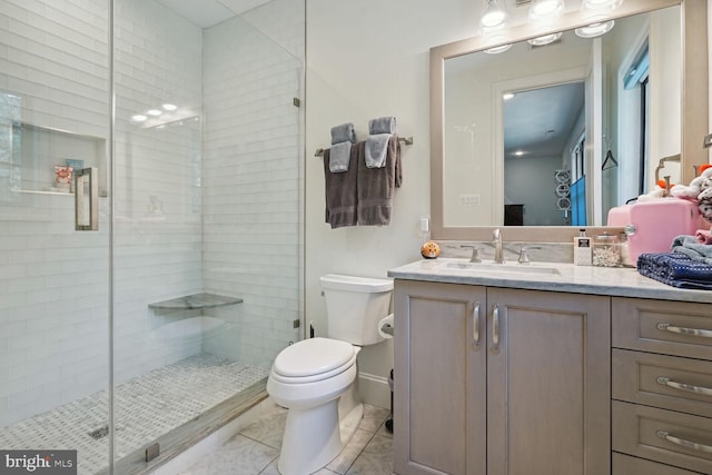 bathroom with tile patterned floors, vanity, toilet, and walk in shower