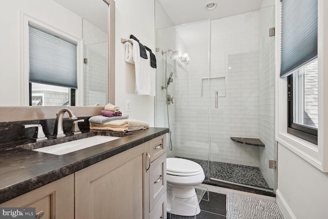 bathroom with toilet, tile patterned flooring, vanity, and walk in shower