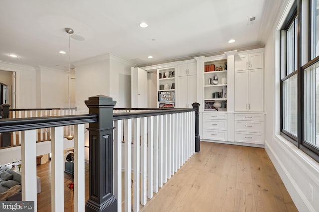 hall featuring crown molding and light hardwood / wood-style flooring