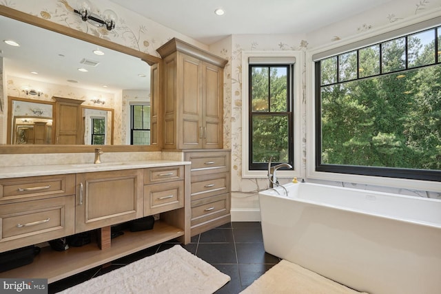 bathroom featuring tile patterned flooring, vanity, and a washtub