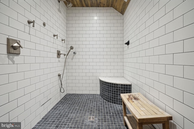 bathroom featuring tile patterned floors, wood ceiling, vaulted ceiling, and tiled shower