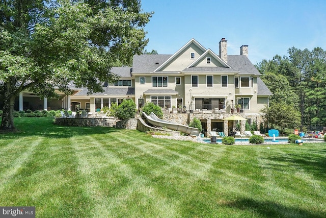 rear view of property featuring a lawn