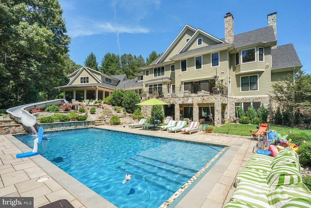 view of swimming pool featuring a patio and a water slide