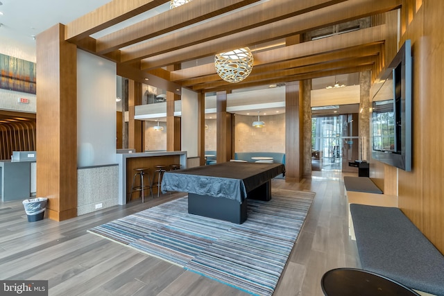 playroom with beam ceiling and wood finished floors