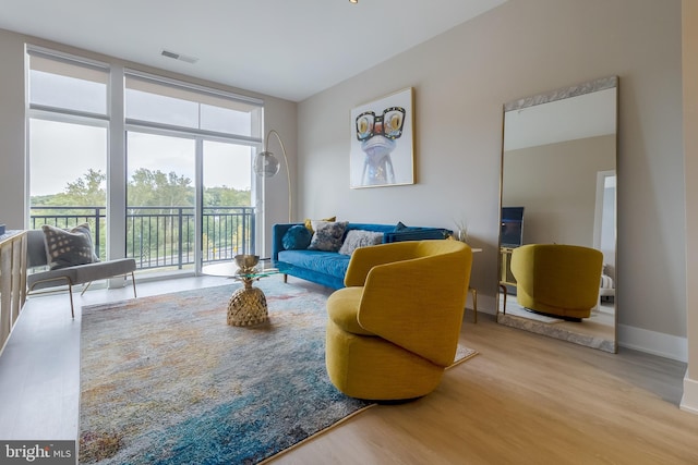 living room featuring wood finished floors, visible vents, and baseboards