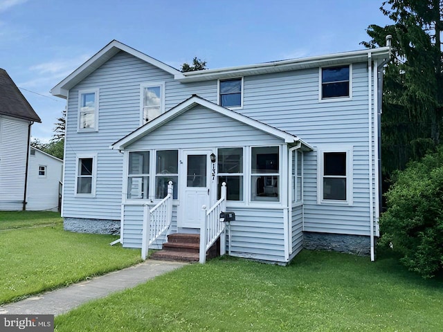 view of front of home featuring a sunroom and a front lawn