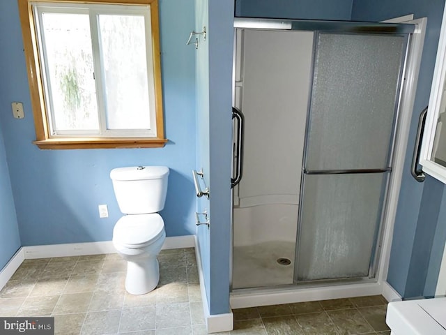 bathroom with toilet, a healthy amount of sunlight, and an enclosed shower