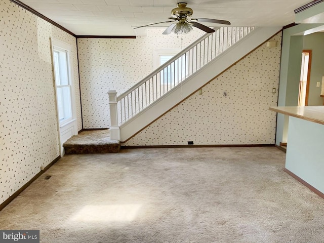 unfurnished living room with carpet, ceiling fan, and ornamental molding