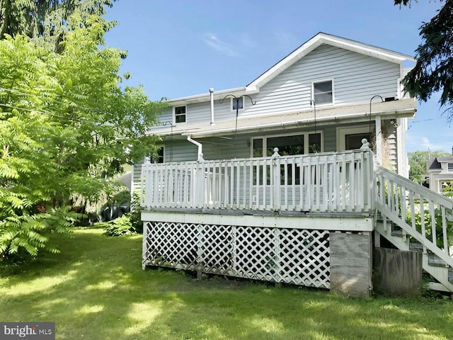 rear view of house with a yard and a deck