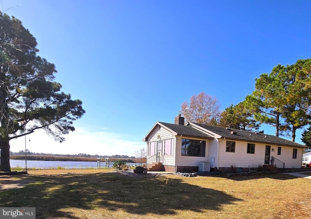 view of side of property featuring a water view and a yard