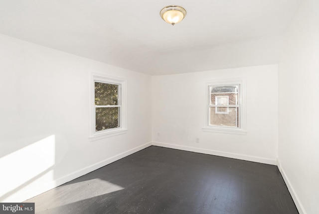 unfurnished room featuring dark wood-type flooring and plenty of natural light