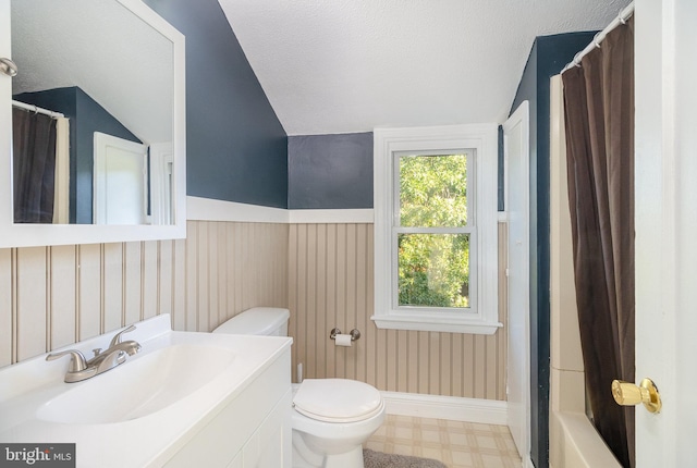 full bathroom featuring toilet, vaulted ceiling, shower / bath combination with curtain, vanity, and a textured ceiling