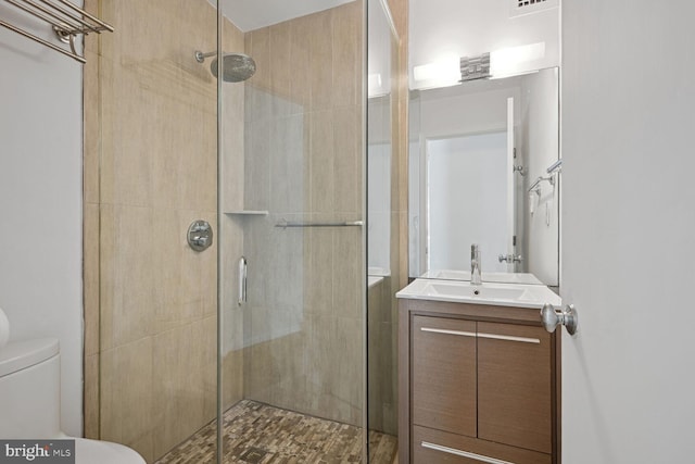 bathroom featuring an enclosed shower, vanity, and toilet