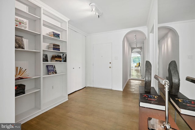 entrance foyer featuring hardwood / wood-style flooring and crown molding