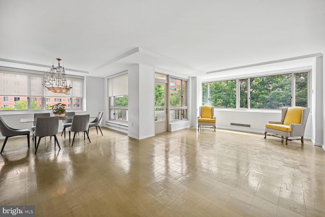 sunroom / solarium featuring a chandelier