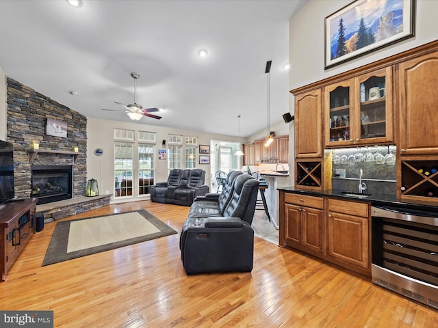 living room featuring lofted ceiling, beverage cooler, and light hardwood / wood-style floors