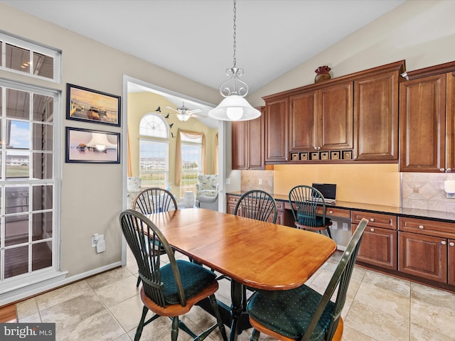 dining area with ceiling fan, light tile patterned flooring, and lofted ceiling