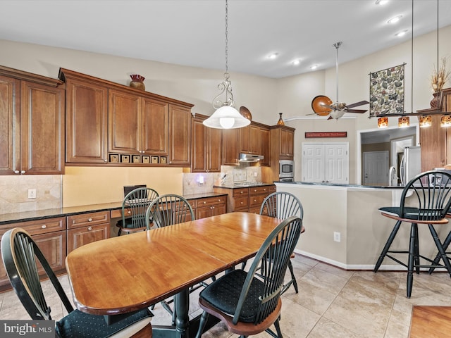 tiled dining room with lofted ceiling and ceiling fan