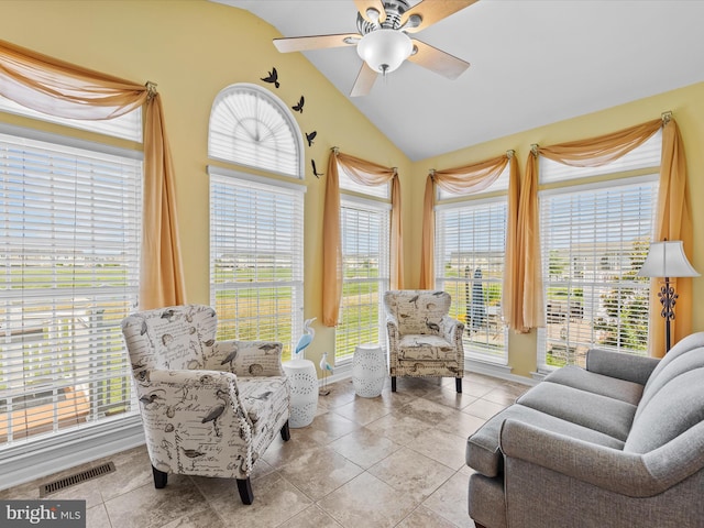 tiled living room featuring ceiling fan, vaulted ceiling, and a healthy amount of sunlight