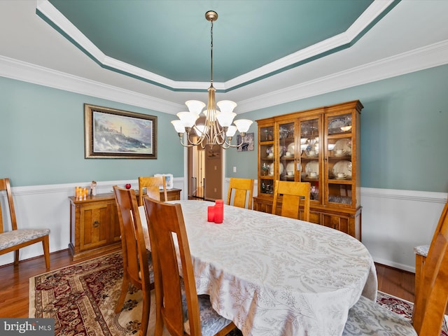 dining space featuring a raised ceiling and ornamental molding