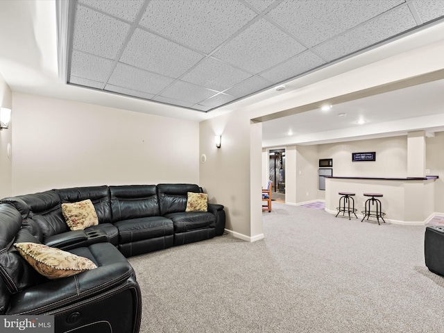 living room featuring a paneled ceiling and carpet