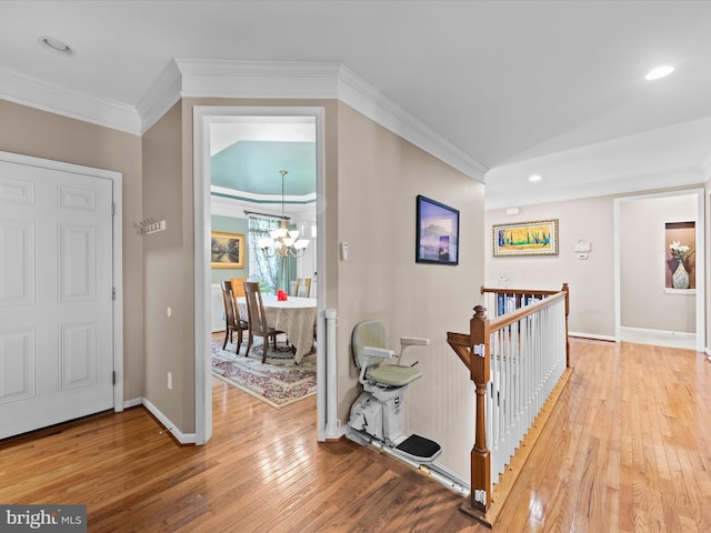 foyer with a notable chandelier, ornamental molding, and wood-type flooring