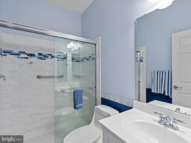 bathroom with an enclosed shower, vanity, and toilet