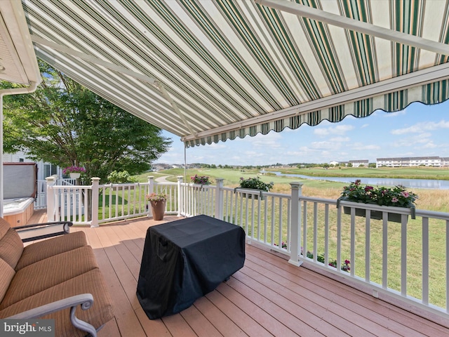 deck with a lawn and a water view