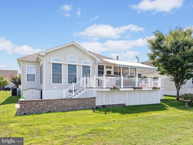 back of house with a deck and a lawn