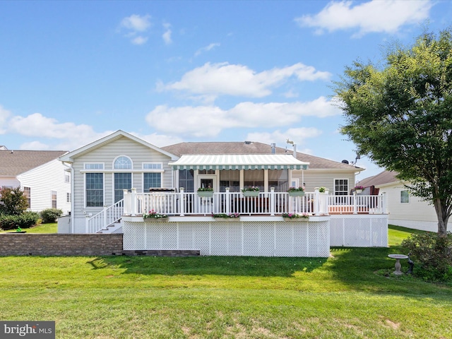 back of property featuring a wooden deck and a lawn