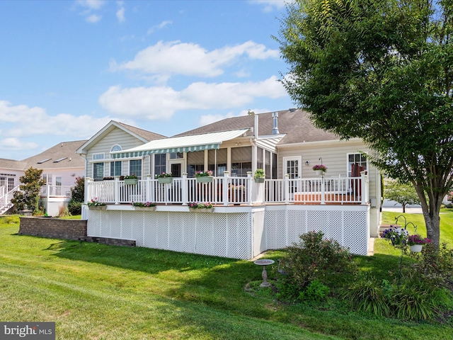 rear view of house with a lawn and a deck