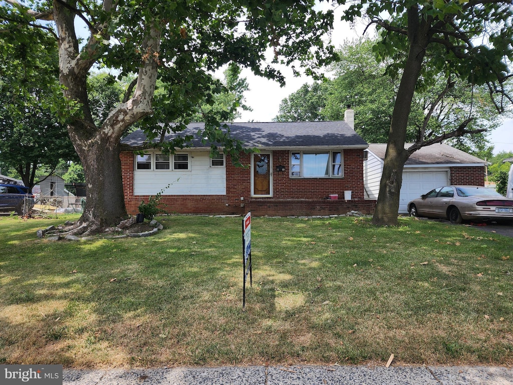 view of front of home featuring a garage and a front lawn