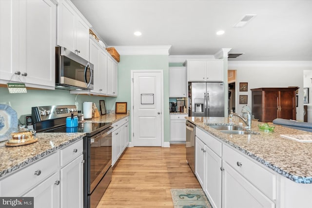 kitchen with white cabinets, sink, ornamental molding, and stainless steel appliances