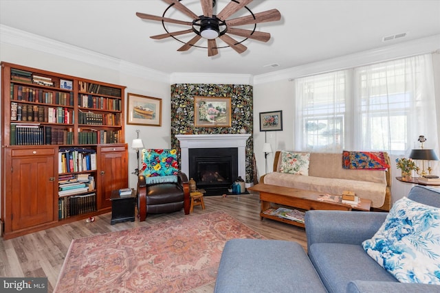 living room featuring ceiling fan, light hardwood / wood-style flooring, and ornamental molding