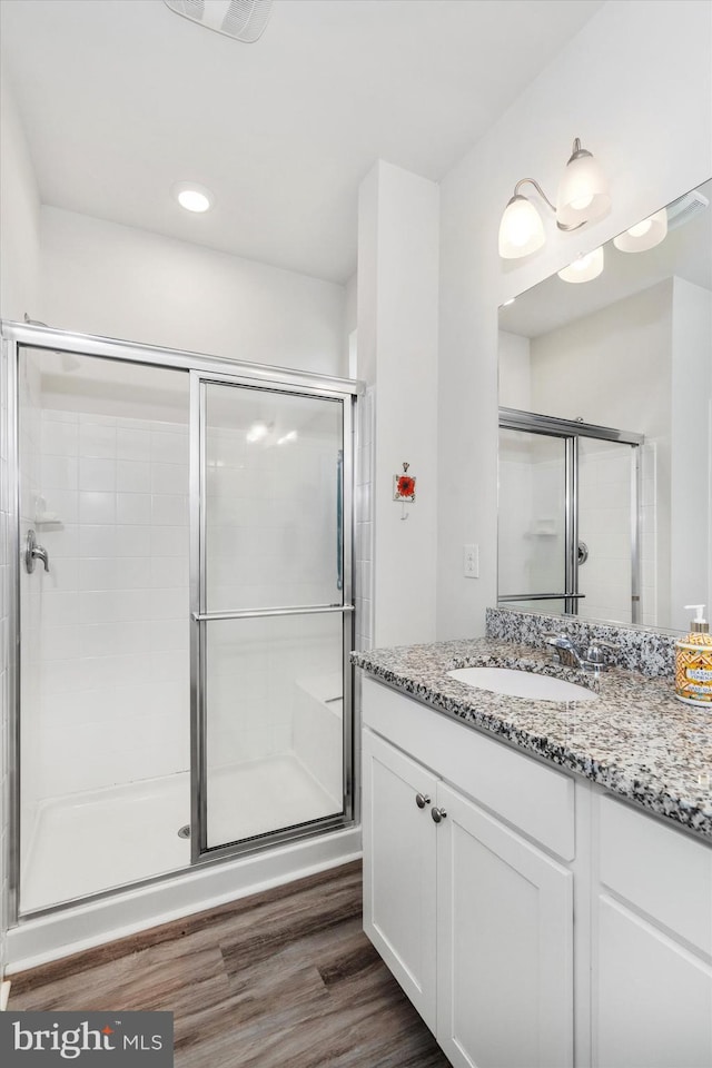 bathroom featuring hardwood / wood-style floors, vanity, and an enclosed shower