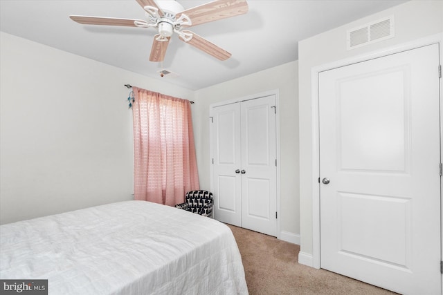 carpeted bedroom featuring ceiling fan and a closet