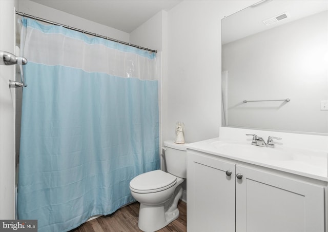 bathroom with a shower with curtain, vanity, wood-type flooring, and toilet