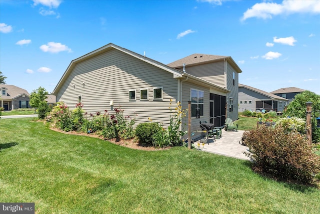 back of house featuring a lawn and a patio