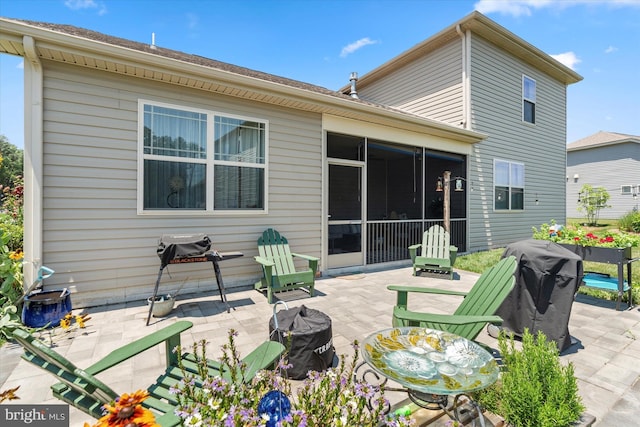 rear view of property featuring a sunroom and a patio