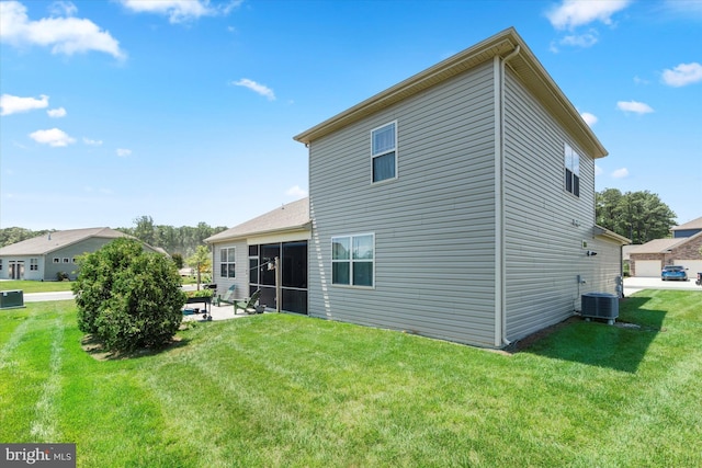 back of property with central AC unit, a patio area, and a lawn