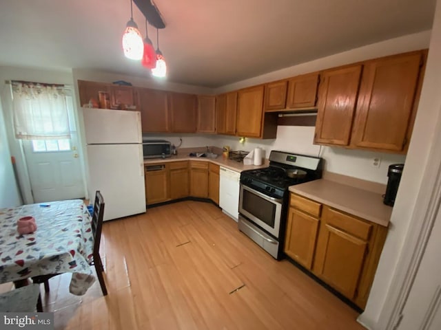 kitchen featuring pendant lighting, light hardwood / wood-style floors, and stainless steel appliances