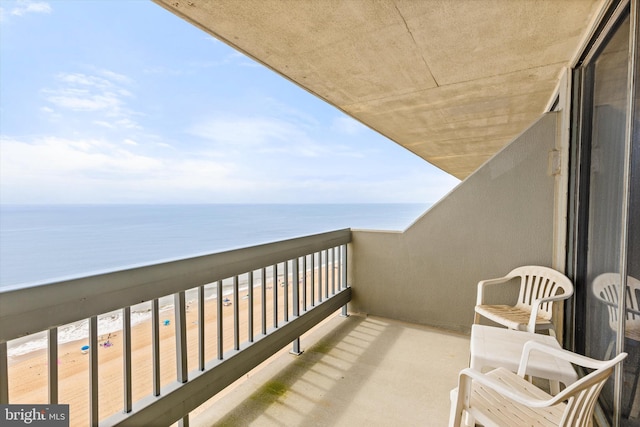 balcony featuring a water view and a beach view