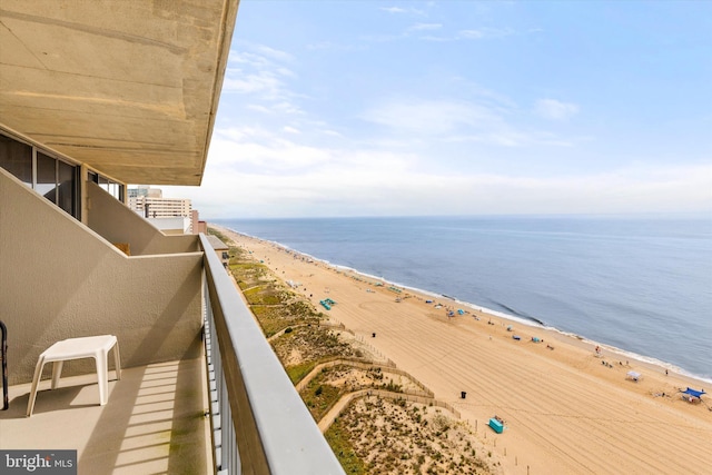 balcony featuring a view of the beach and a water view