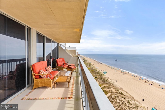 balcony with a water view and a view of the beach