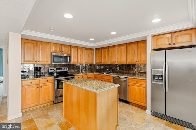 kitchen featuring light stone countertops, appliances with stainless steel finishes, decorative backsplash, sink, and a center island