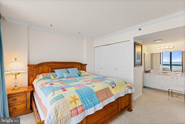 carpeted bedroom featuring ensuite bathroom, a closet, crown molding, and sink