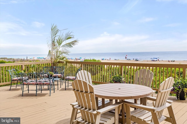 wooden terrace featuring a water view and a view of the beach