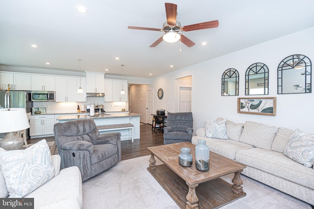 living room with ceiling fan and light hardwood / wood-style flooring