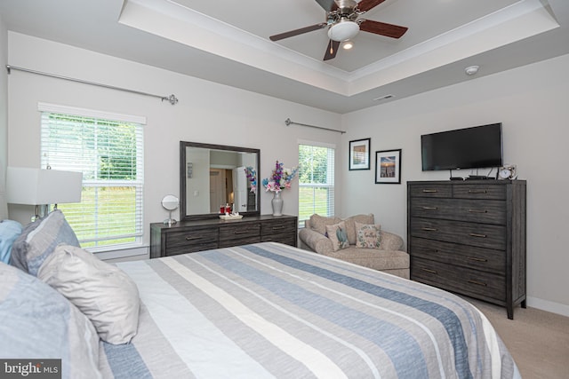 bedroom with crown molding, ceiling fan, a tray ceiling, and light carpet