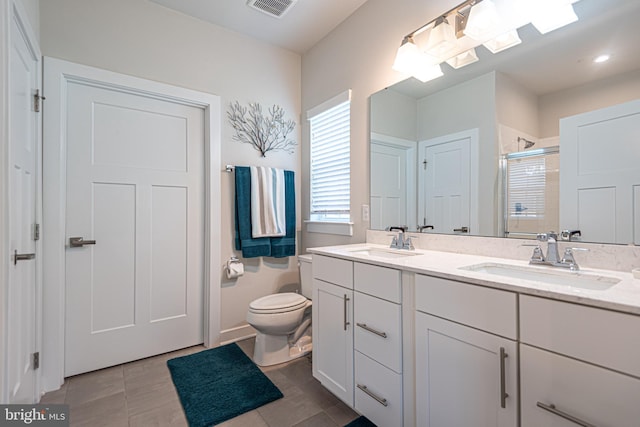 bathroom with vanity, a shower with door, tile patterned floors, and toilet